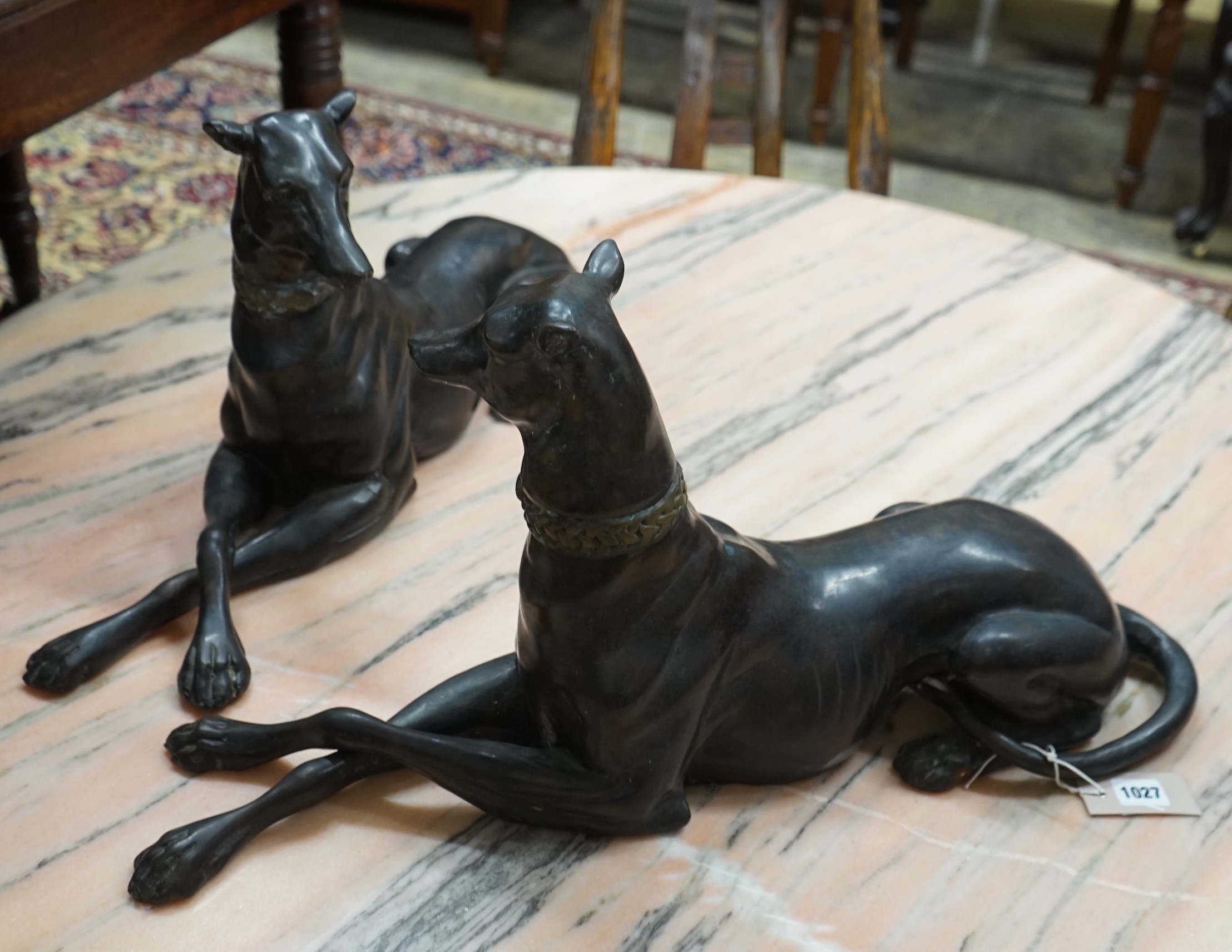 A pair of bronze recumbent greyhounds, length 67cm, height 32cm